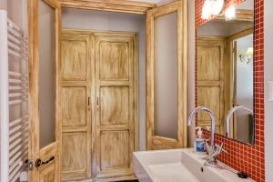 a bathroom with a sink and a wooden door at Casa Vermella in Orriols +35 photos