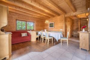 a living room with a red couch and a table at Bergchalet Fuchsberger in Verano