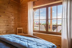 a bedroom with a bed and a large window at Bergchalet Fuchsberger in Verano