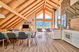 a kitchen and dining room with a table and chairs at Duplex Sauna privé Vénosc Le 1618 in Les Deux Alpes