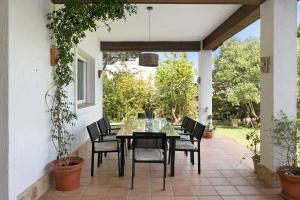 a patio with a black table and chairs on it at Sol, playa y diversion en Roche in Roche