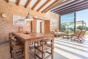a dining room with a wooden table and chairs at Son Coranta in Campos