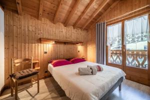 a bedroom with two beds in a room with wooden walls at Chalet La Grangerie in Montriond