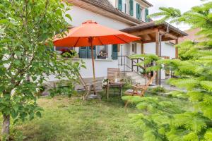 a patio with an umbrella and a table and chairs at Landhausappartment in Bermatingen