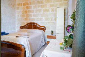 a bedroom with a bed and a brick wall at La Casa di Marta in Faccia di Trippa