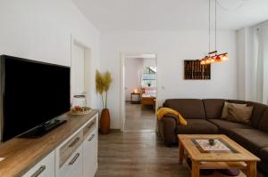 a living room with a couch and a flat screen tv at Haus Scheve in Rhauderfehn