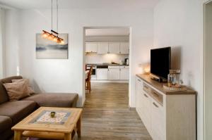 a living room with a couch and a tv at Haus Scheve in Rhauderfehn