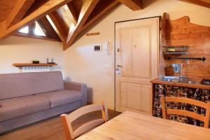 a living room with a couch and a kitchen at Il Piccolo Sogno in Temù
