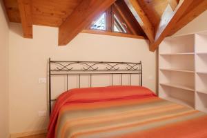 a bedroom with a bed with a wooden ceiling at Il Piccolo Sogno in Temù