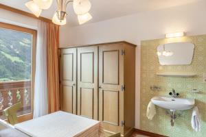 a bathroom with a sink and a table and a window at Ferienwohnung Dornauer in Hippach
