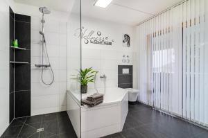a white bathroom with a tub and a toilet at Turmalin in Überlingen +24 photos