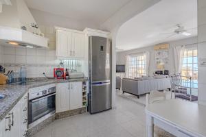 a kitchen with a refrigerator and a living room at Villa el Yuka , heated pool in Callao Salvaje