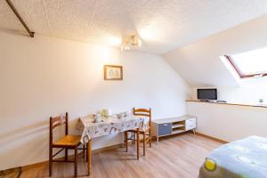 a room with a table and chairs and a bed at La résidence du vieux four in Saint-Geniès