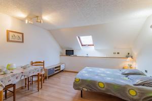 a bedroom with a bed and a table and chairs at La résidence du vieux four in Saint-Geniès