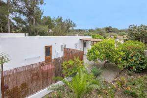 a white house with a fence and trees at Pensión las 3 Golondrinas in Santa Eularia des Riu