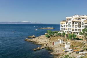 a large building on the shore of a body of water at La cargolera in L'Escala
