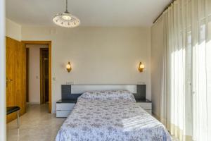 a bedroom with a bed and a large window at La cargolera in L'Escala