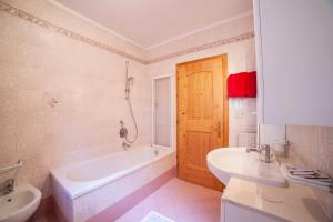 a bathroom with a tub and a toilet and a sink at Sonnenparadies Apartement 3 in Saltusio