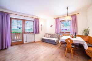 a living room with a table and purple curtains at Sonnenparadies Apartement 3 in Saltusio +15 photos