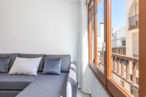 a gray couch in a room with a window at Can Lopits in L'Escala