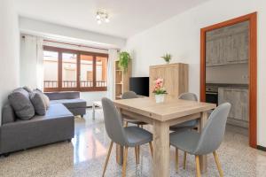 a living room with a wooden table and chairs at Can Lopits in L'Escala