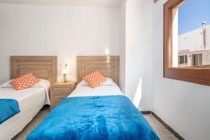 a bedroom with two beds and a window at Can Lopits in L'Escala