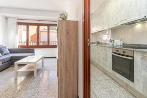 a kitchen and living room with a couch and a table at Can Lopits in L'Escala +13 photos