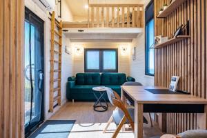 ein Wohnzimmer mit einer grünen Couch und einem Tisch in der Unterkunft Tiny House Ingo John 'Shadow' in Sandstedt