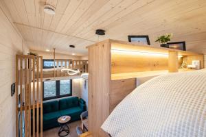 Ein Schlafzimmer in einem Minihaus mit einem Bett und einer Couch in der Unterkunft Tiny House Ingo John 'Shadow' in Sandstedt