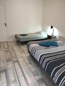a bedroom with two beds and a wooden floor at Chez Gaston in Bourges