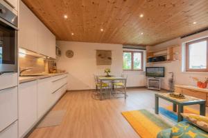 a kitchen and living room with a table and a couch at Ferienwohnung Serlesblick in Mieders