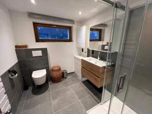 a bathroom with a shower and a toilet and a sink at Ferienwohnung Serlesblick in Mieders +20 photos