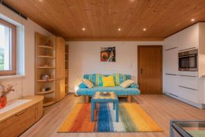 a living room with a blue couch and a table at Ferienwohnung Serlesblick in Mieders