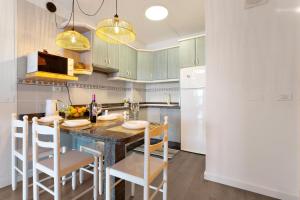 a kitchen with a table and chairs and a refrigerator at Milailea in Tacoronte