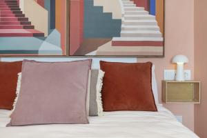 a bed with two pillows and a painting on the wall at Apartamento The Stairs 2 11 in Tarifa +15 photos