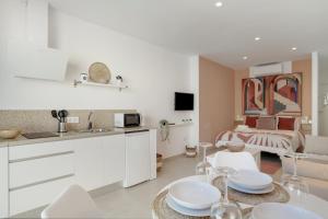 a kitchen and living room with a bed in the background at Apartamento The Stairs 2 11 in Tarifa