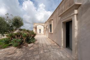 an entrance to a building with an arch and plants at Anghelos in Lizzanello