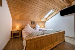 a large bed in a room with a wooden ceiling at Apartment Waldesruh in Mühlbach +12 photos