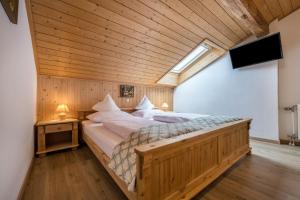 a large bed in a room with a wooden ceiling at Apartment Waldesruh in Mühlbach