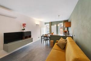 a living room with a couch and a kitchen at Gemhouse Smeraldo garda lake in Gargnano