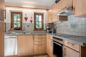a kitchen with wooden cabinets and a sink at Thaleralm in Obereggen