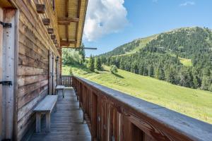 a balcony of a cabin with a bench on it at Thaleralm in Obereggen