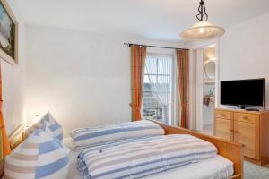 a bedroom with two beds and a television in it at Haus Luise in Lenzkirch in Lenzkirch