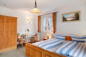 a bedroom with a bed with blue and white striped pillows at Haus Luise in Lenzkirch in Lenzkirch