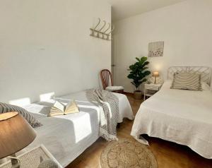 a bedroom with two beds and a table and chairs at White Sands 3.07 in Arenal d'en Castell +19 photos