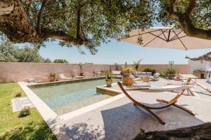 a pool with a table and chairs and an umbrella at Le Giarre - Villa Con Piscina in Marausa