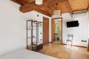 a bedroom with a bed and a tv on a wall at Il Serraglio Rooms in Valeggio sul Mincio