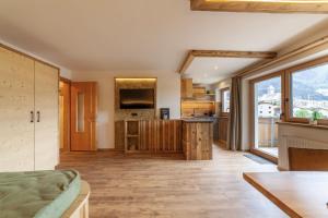 a large kitchen with wooden floors and a large window at Mühlanderhof Apt Endkopf in Resia