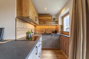 a kitchen with wooden cabinets and a sink at Mühlanderhof Apt Endkopf in Resia +21 photos