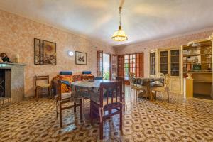 a living room with a table and chairs and a fireplace at Casa vacanza Elena in Sarroch
